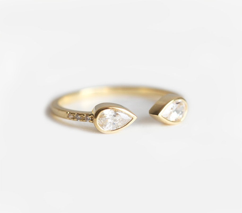 Gold horseshoe ring with white pear-shaped diamonds