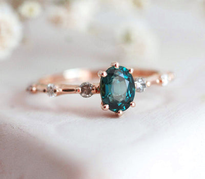 Oval-shaped teal sapphire ring with salt and pepper diamond gemstones