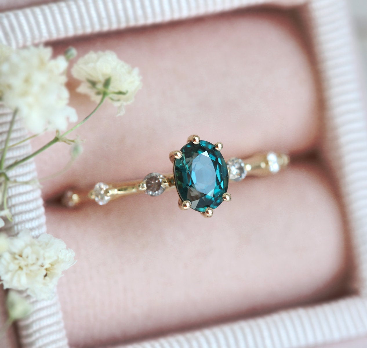 Oval-shaped teal sapphire ring with salt and pepper diamond gemstones