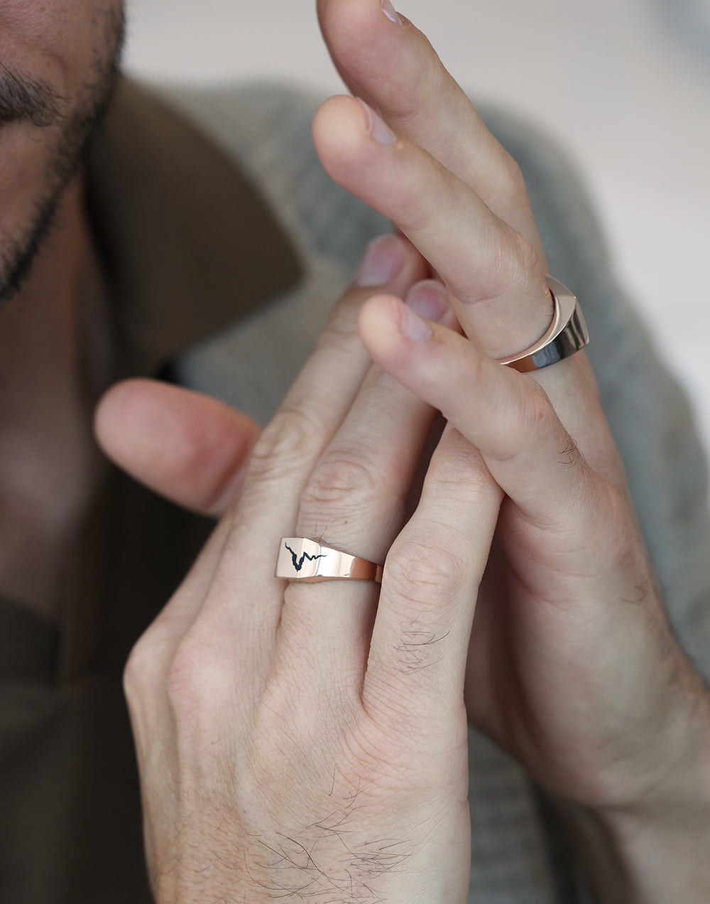 Close-up of a man's hands showcasing the Orson Crushed Signet Ring in gold.