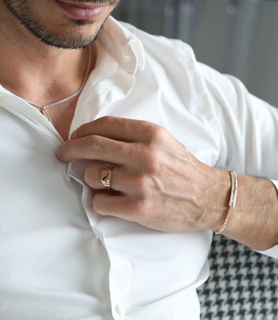 A man wearing a gold Orson Crushed Signet Ring, showcasing an elegant design in gold or platinum.