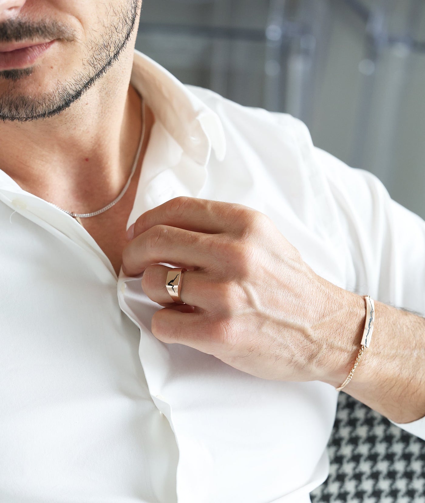 A man's hand wearing an Orson cracked signet ring with black inlay.