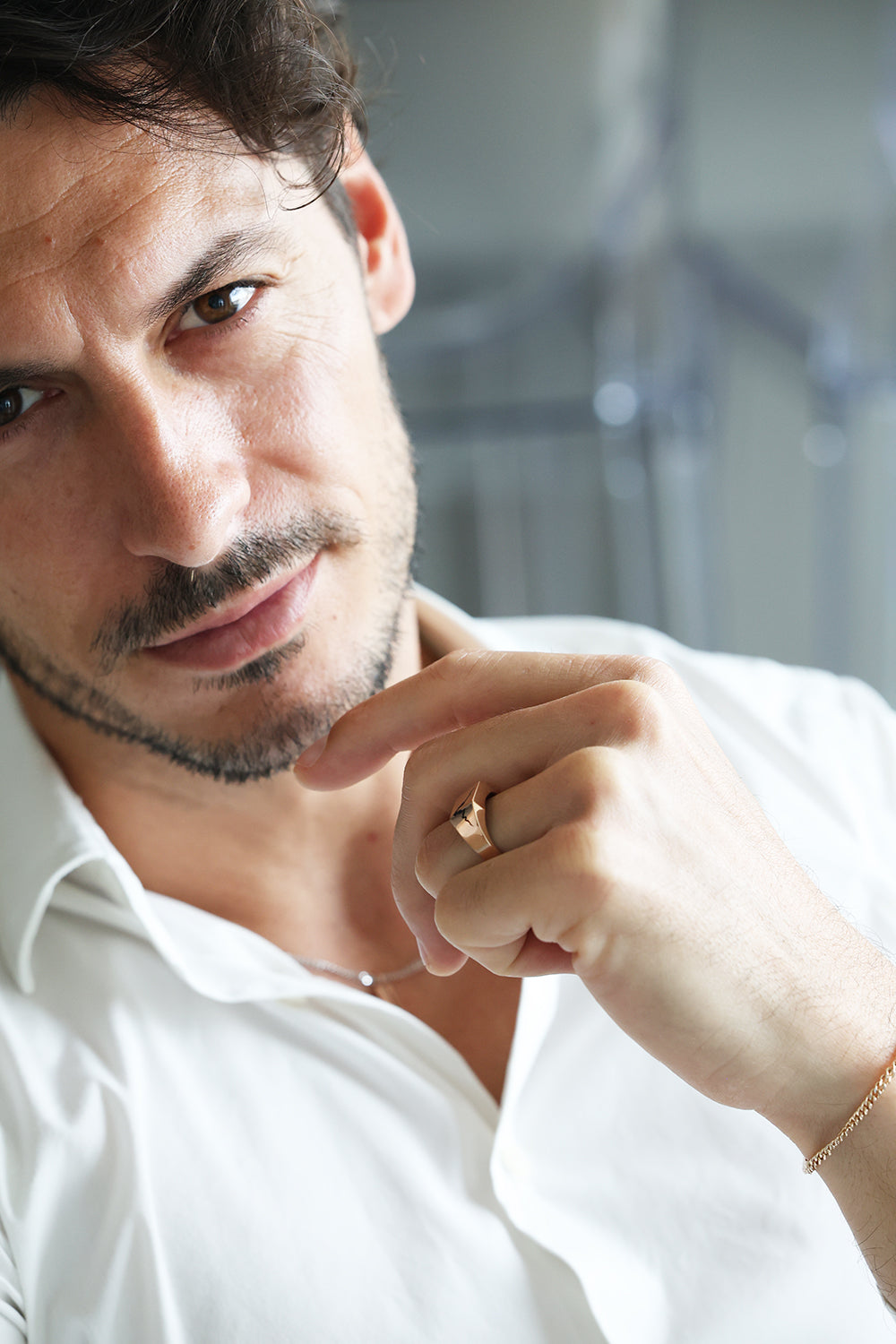 A man wearing a white shirt with a beard and mustache, showcasing the Orson cracked signet ring with black inlay.