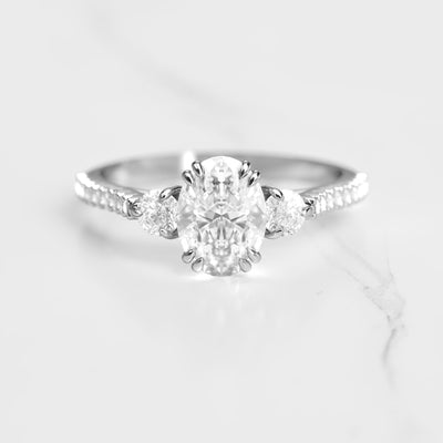 Oval half pave diamond ring with accent stones