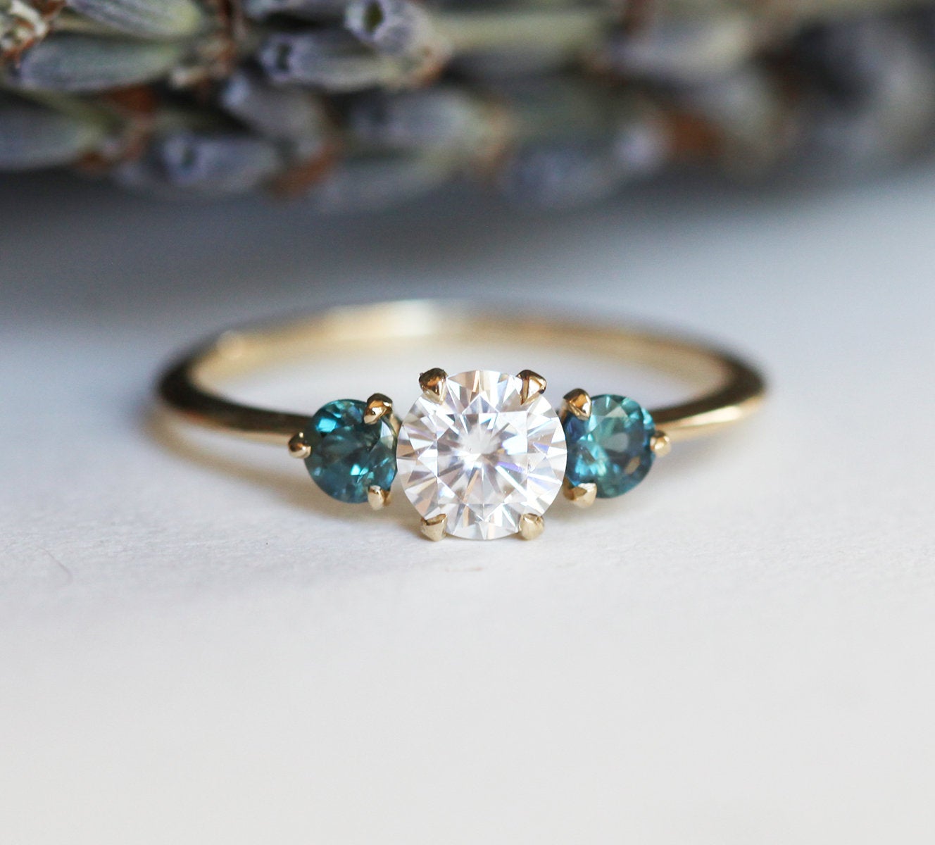 Round moissanite and teal sapphire engagement ring