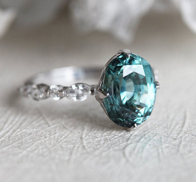 Vintage oval-shaped teal sapphire with side diamonds