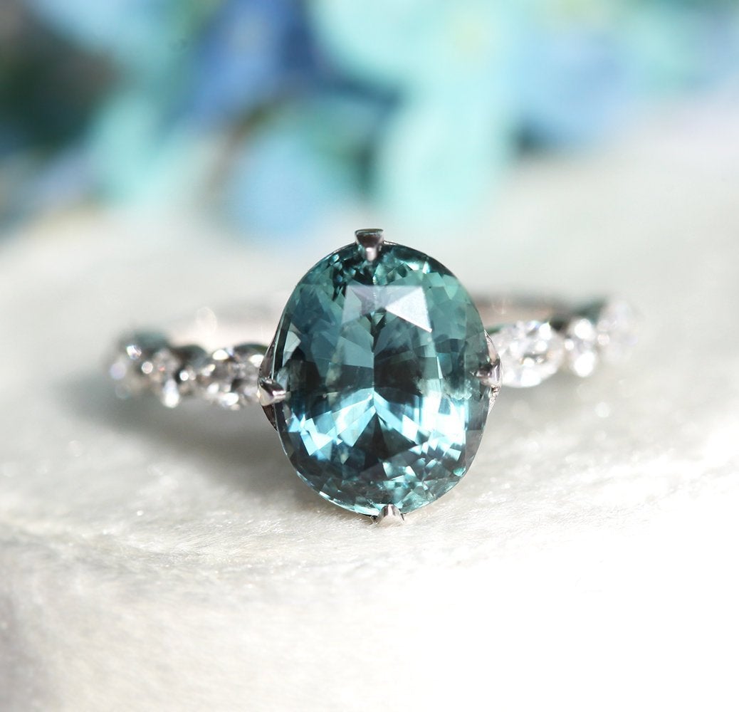 Vintage oval-shaped teal sapphire with side diamonds