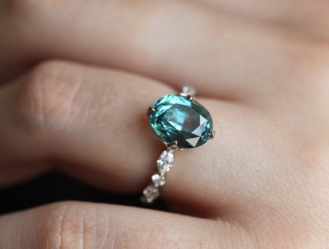 Vintage oval-shaped teal sapphire with side diamonds