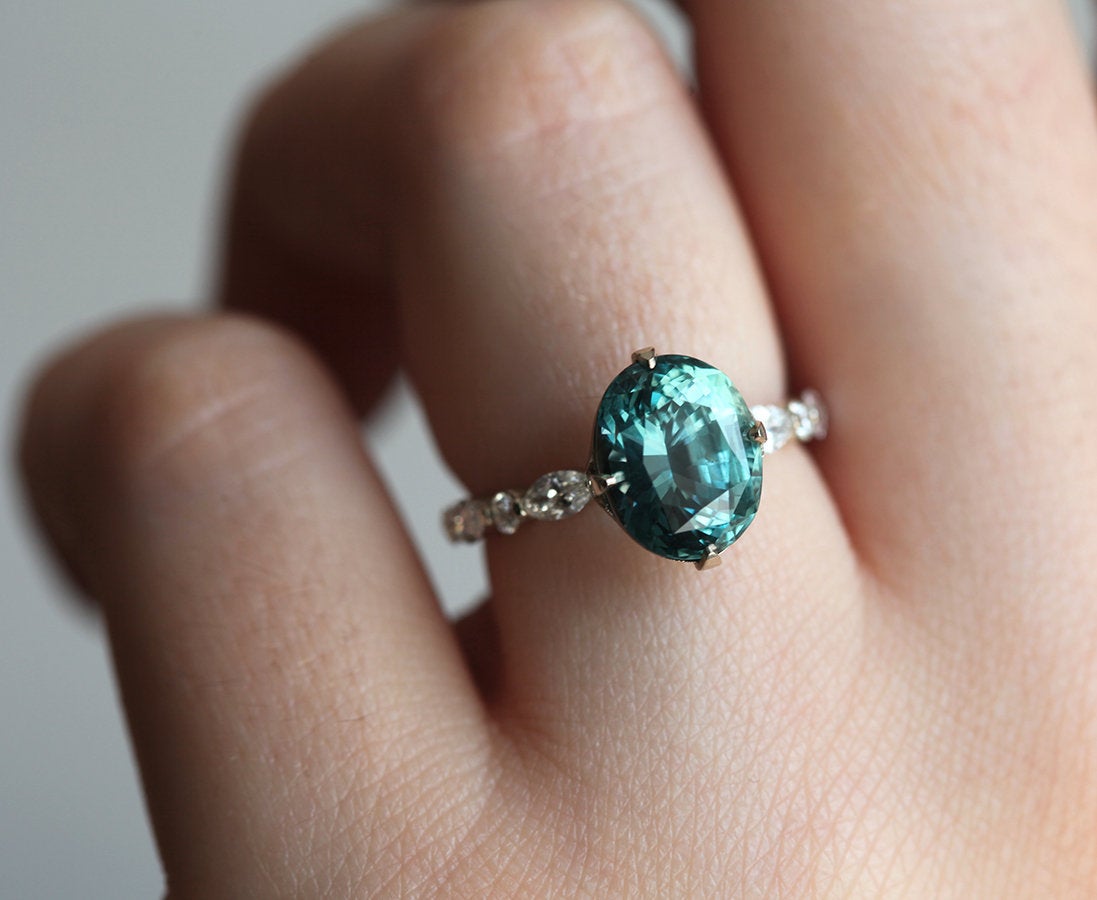 Vintage oval-shaped teal sapphire with side diamonds