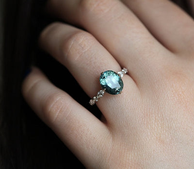 Vintage oval-shaped teal sapphire with side diamonds