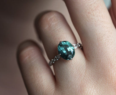 Vintage oval-shaped teal sapphire with side diamonds