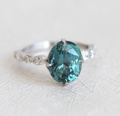 Vintage oval-shaped teal sapphire with side diamonds