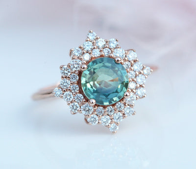 Round teal sapphire ring with diamond halo