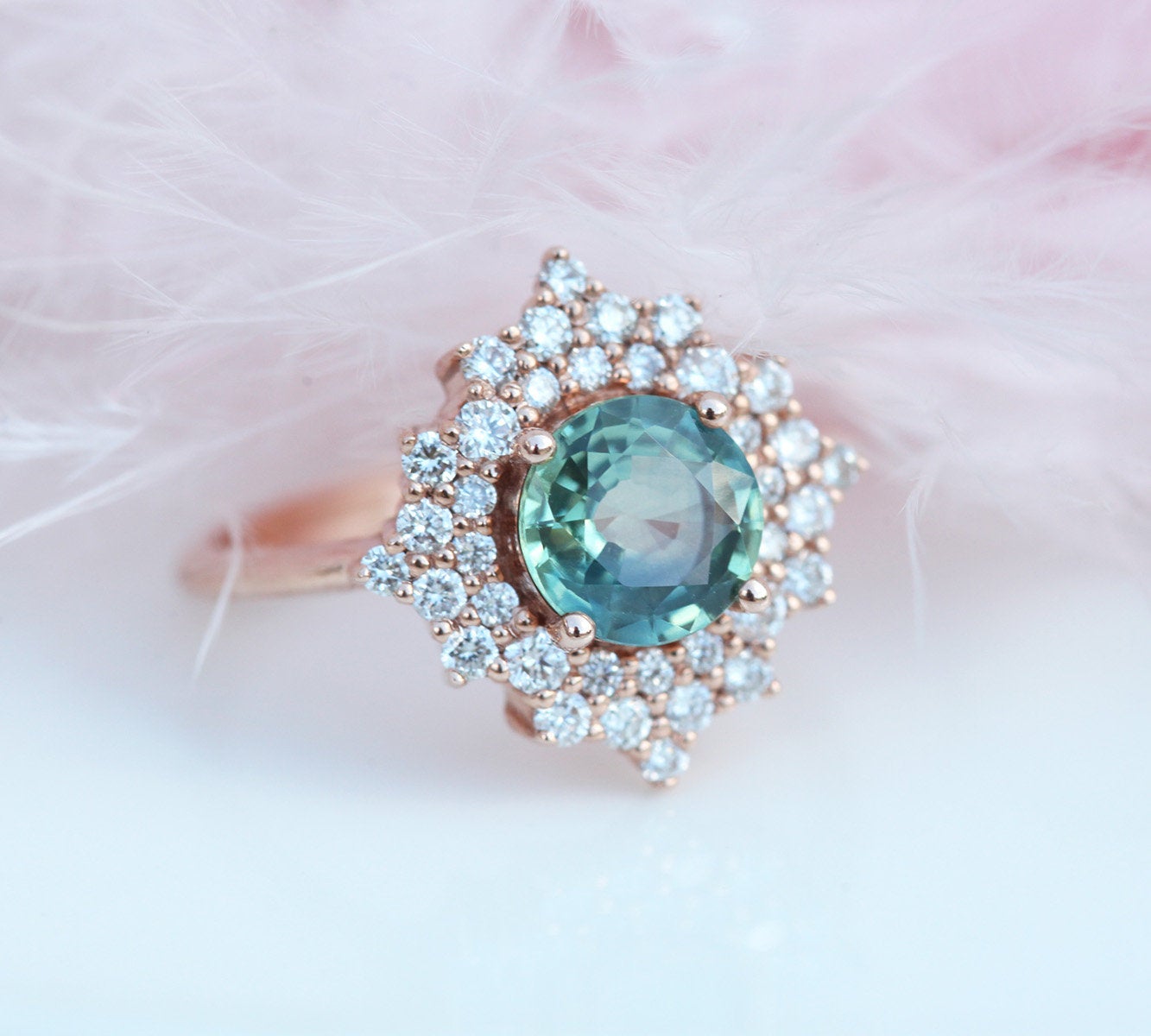 Round teal sapphire ring with diamond halo