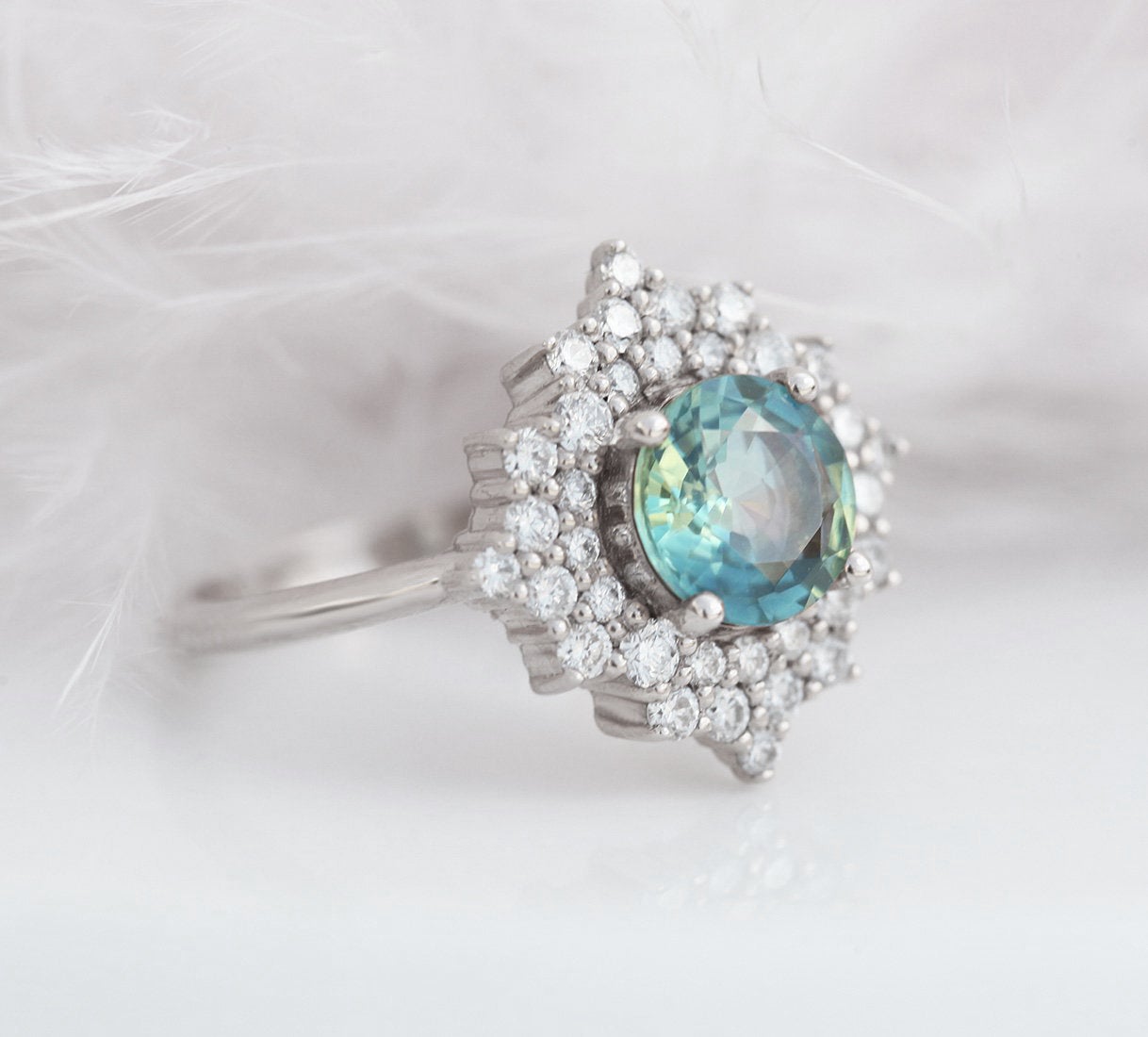 Round teal sapphire ring with diamond halo