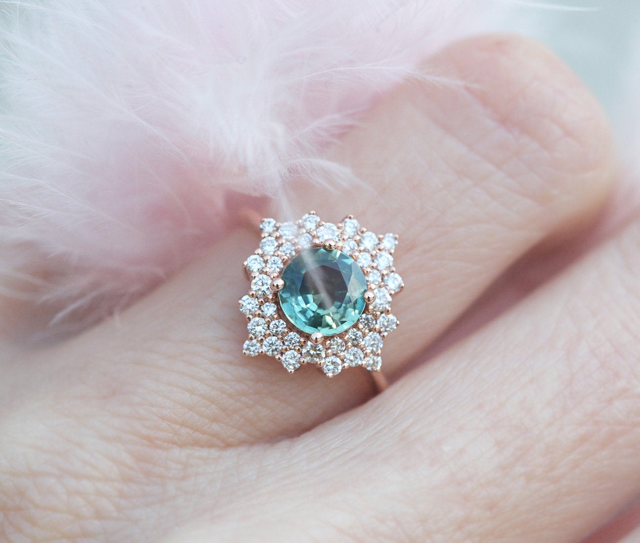 Round teal sapphire ring with diamond halo