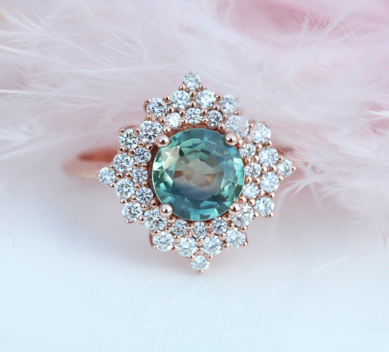 Round teal sapphire ring with diamond halo