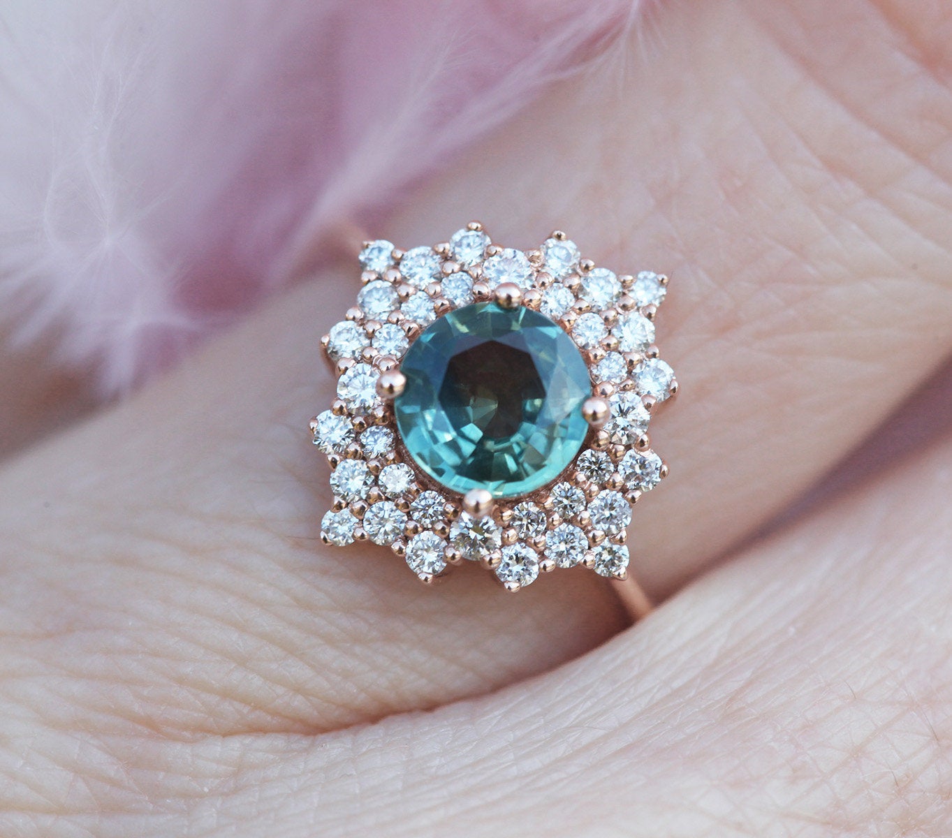 Round teal sapphire ring with diamond halo