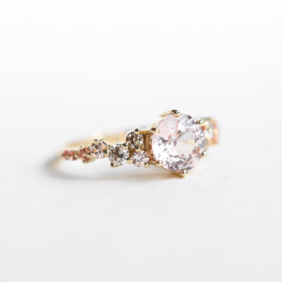 Round peach pink sapphire engagement ring with diamond cluster