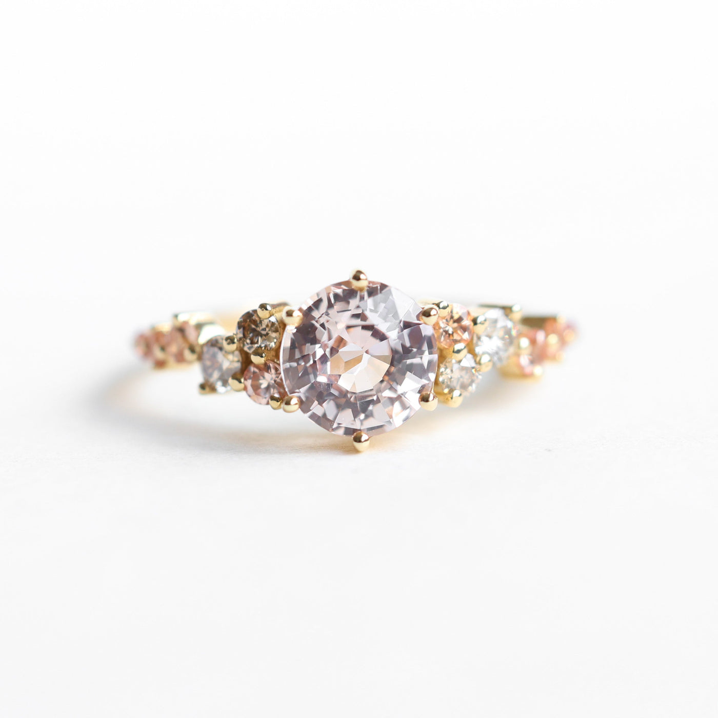 Round peach pink sapphire engagement ring with diamond cluster