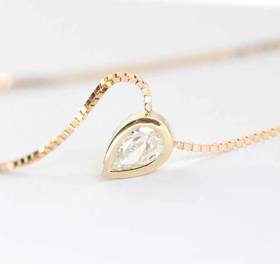 Gold necklace with white pear-shaped diamond