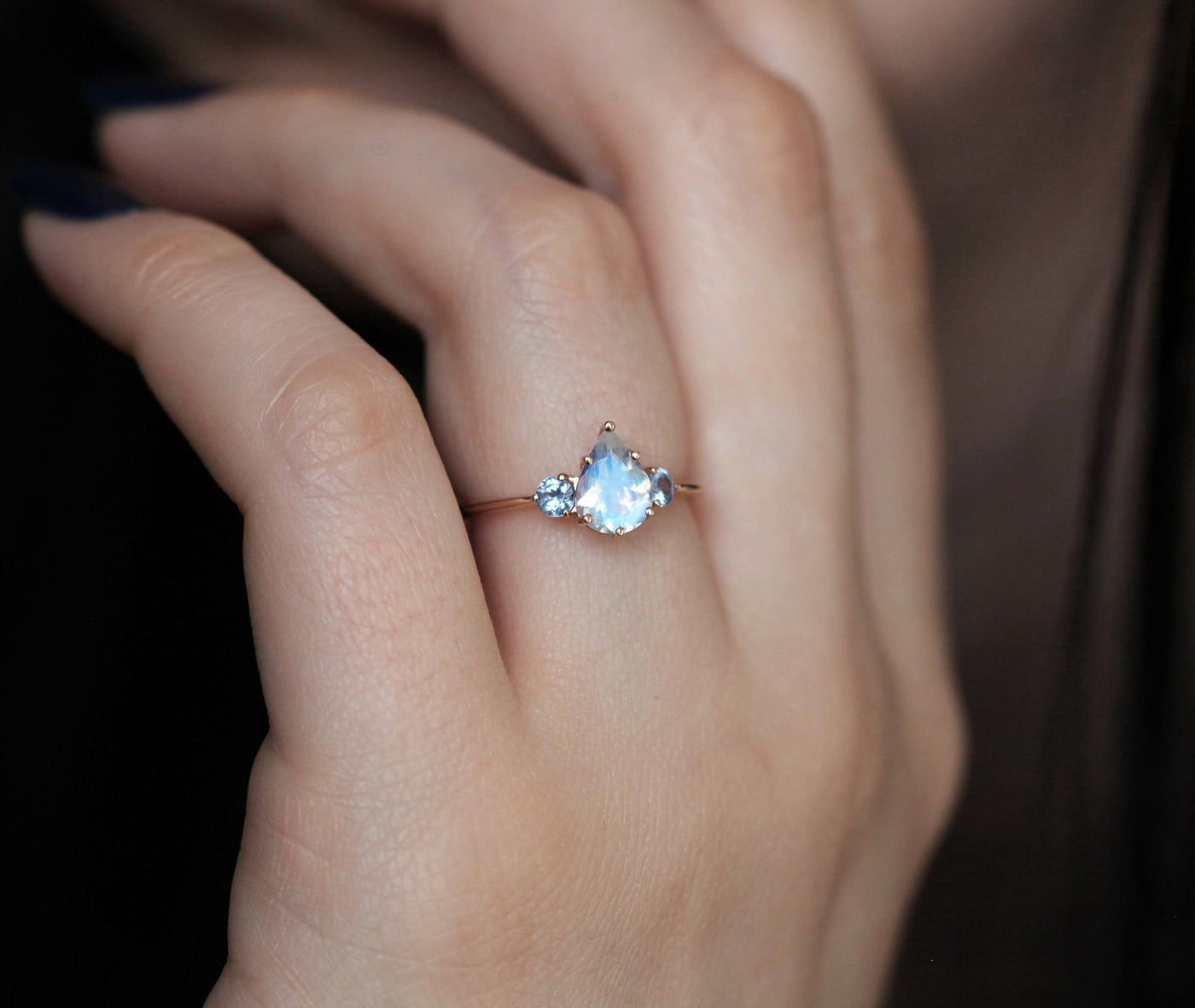 Pear-shaped white moonstone ring with side sapphires