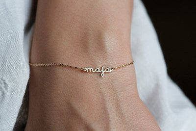 Gold chain bracelet with personalized name and round green emerald