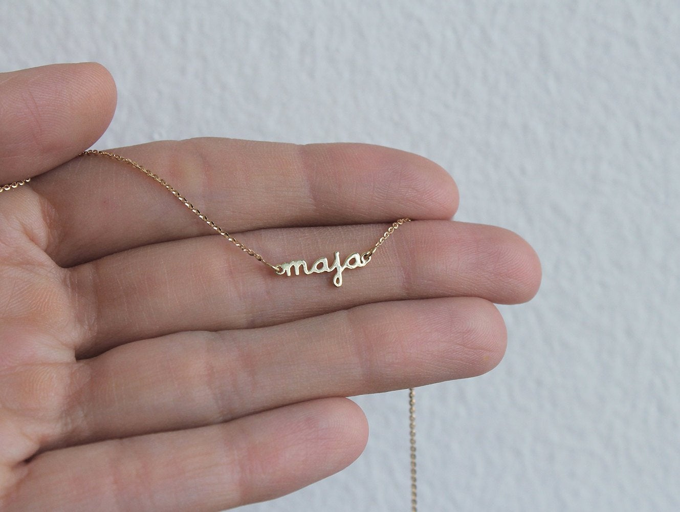 Gold chain bracelet with personalized name and round green emerald