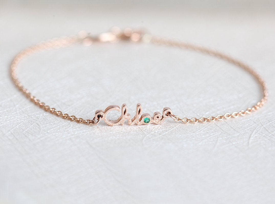 Gold chain bracelet with personalized name and round green emerald