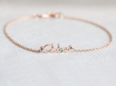 Gold chain bracelet with personalized name and round green emerald