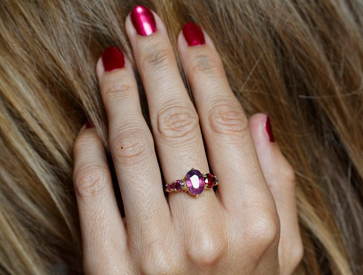 Oval-shaped sapphire cluster ring with ruby, garnet and diamond stones