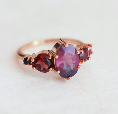 Oval-shaped sapphire cluster ring with ruby, garnet and diamond stones