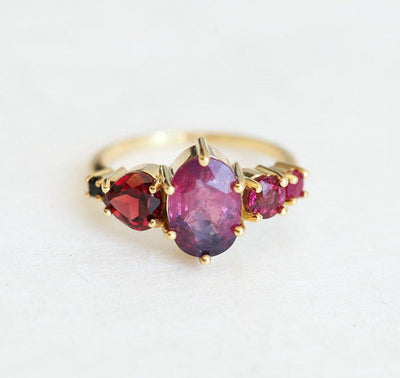 Oval-shaped sapphire cluster ring with ruby, garnet and diamond stones