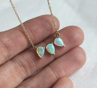 Gold chain with three white pear-shaped australian opal stones