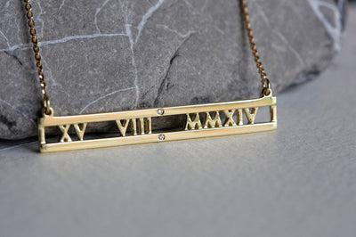 Gold chain necklace with personalized roman numerals bar and white round diamonds