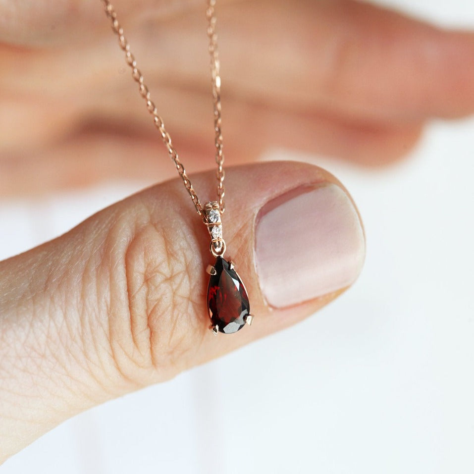 Gold chain with red pear-shaped garnet and round white diamonds