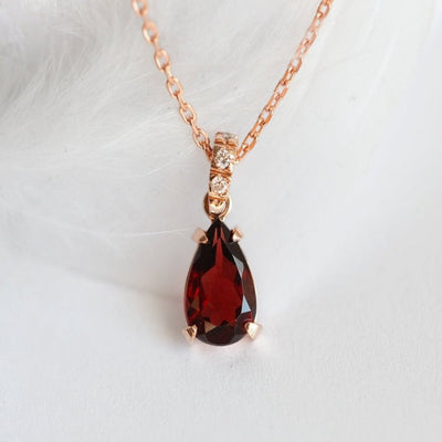 Gold chain with red pear-shaped garnet and round white diamonds