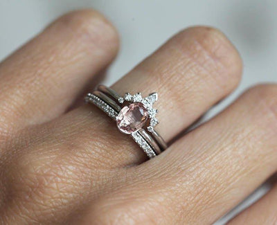 Oval peach pink sapphire ring with white side diamonds
