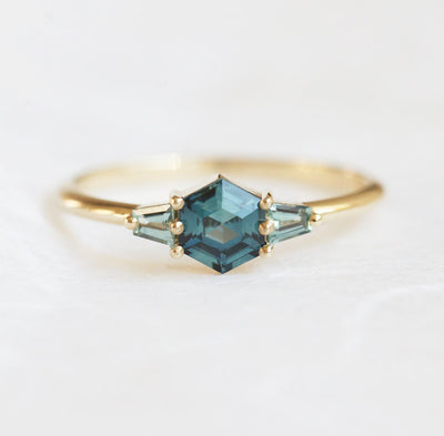 Hexagon-shaped teal sapphire ring with trapezoid side sapphires
