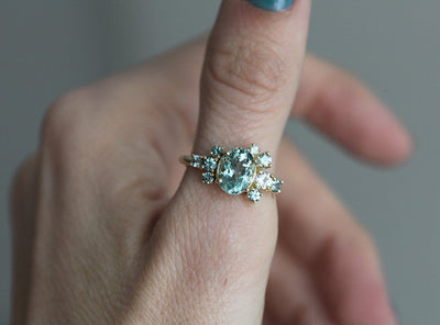 Oval green tourmaline cluster ring with round sapphires