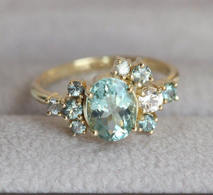 Oval green tourmaline cluster ring with round sapphires