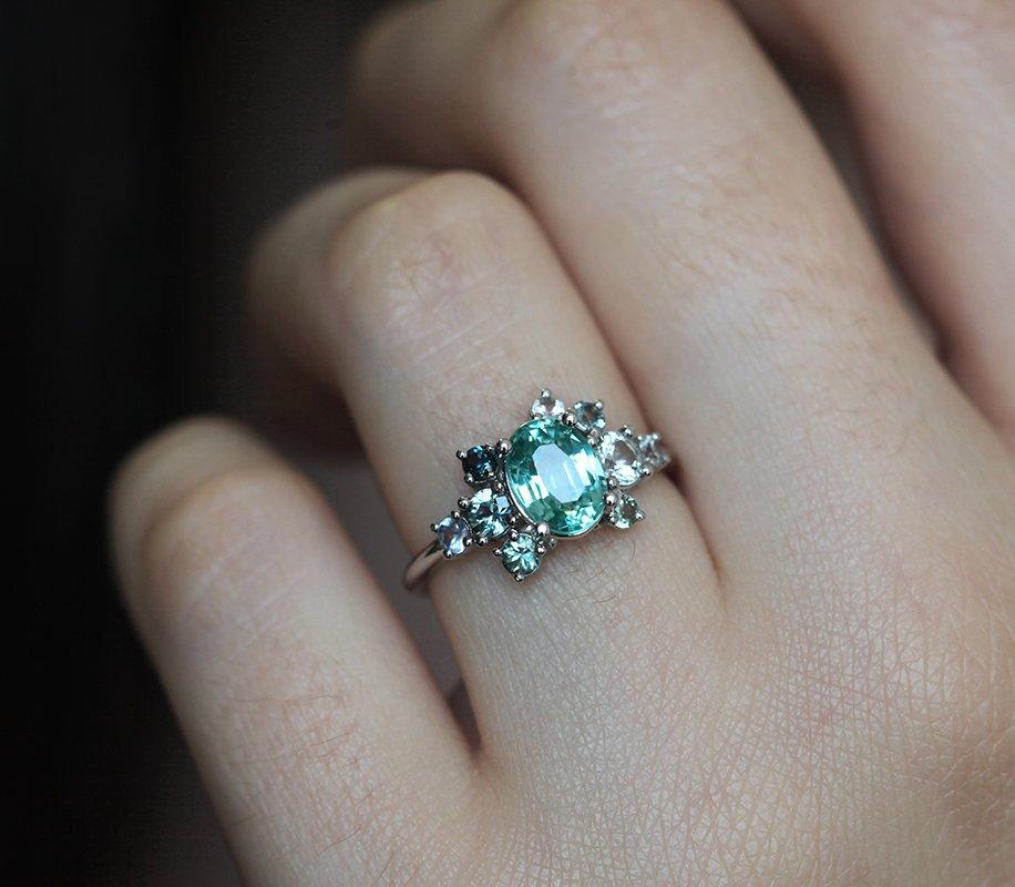 Oval green tourmaline cluster ring with round sapphires