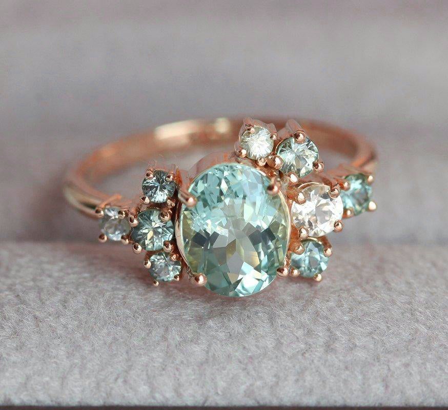 Oval green tourmaline cluster ring with round sapphires