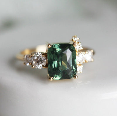 Cushion-cut green sapphire cluster ring with white diamonds