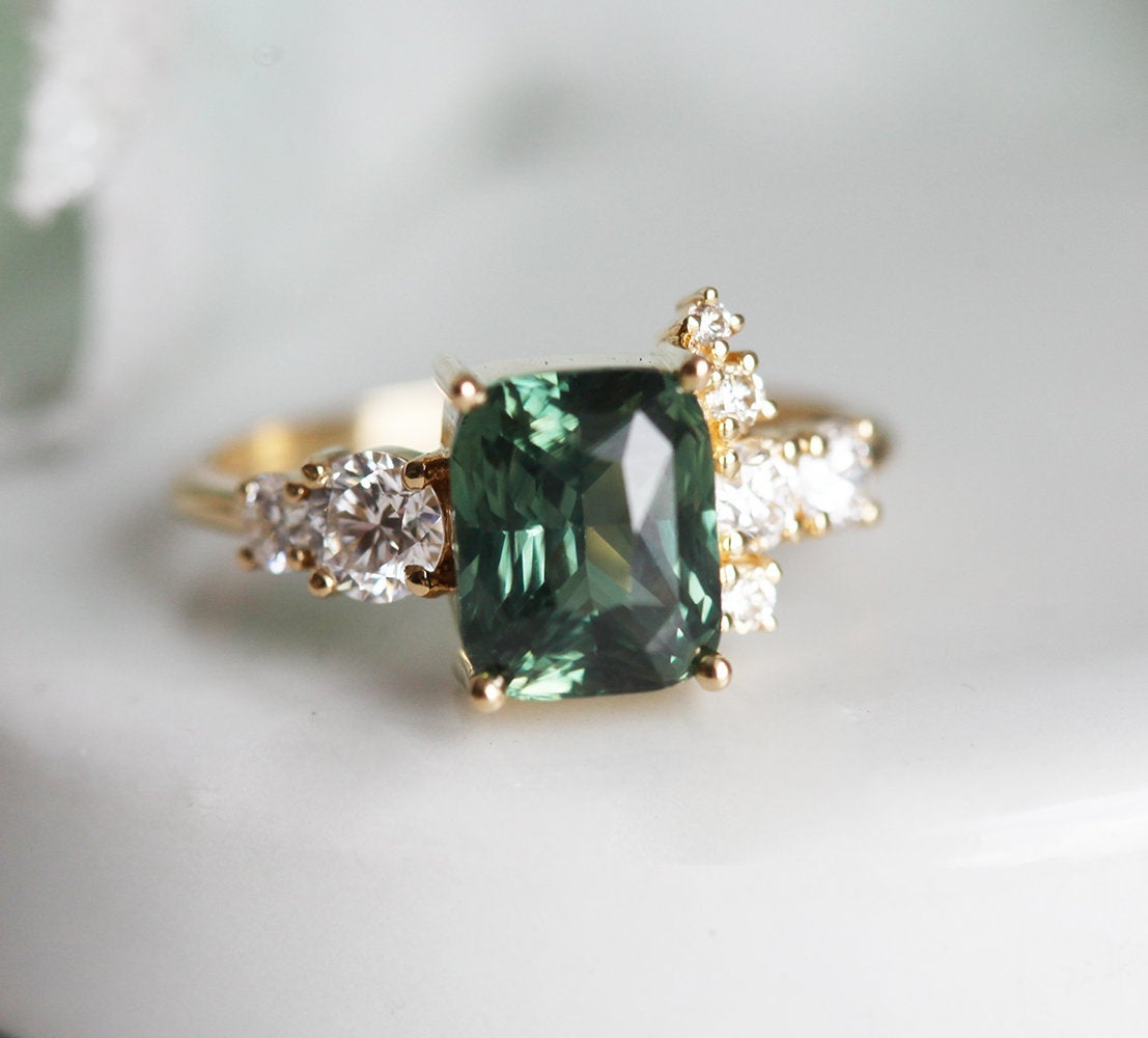 Cushion-cut green sapphire cluster ring with white diamonds
