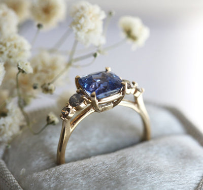 Cushion-cut blue sapphire cluster ring with round salt and pepper diamonds