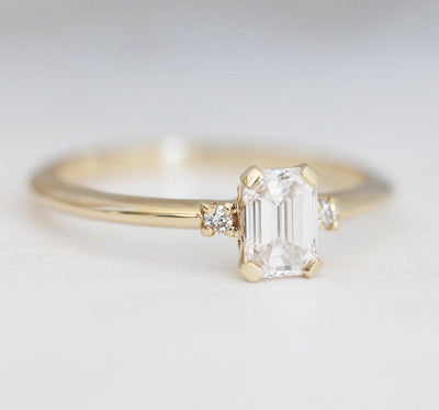 Eleganten in preprost diamantni prstan s smaragdnim rezom s stranskimi diamanti
