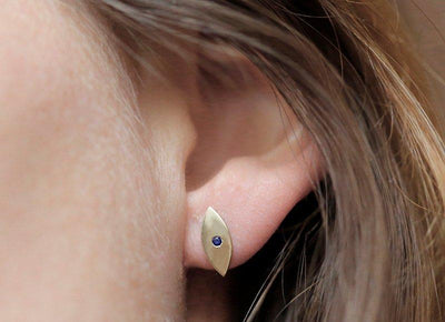 Evil-eye-shaped stud earrings with round blue sapphires