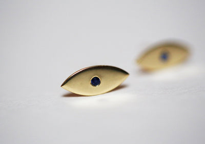 Evil-eye-shaped stud earrings with round blue sapphires