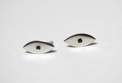 Evil-eye-shaped stud earrings with round blue sapphires